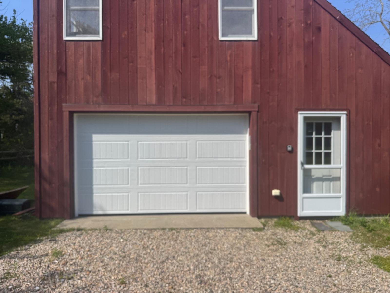 Bluefin white garage door on red barn-style building exterior